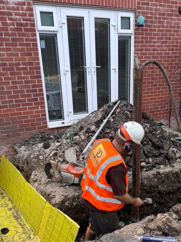 Residential piling and ground beams. Man in hole whilst piling for a house extension